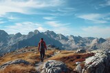 Fototapeta Uliczki - Hiker admiring majestic mountain peaks in scenic alpine landscape. Outdoor adventure, travel, wilderness exploration concept