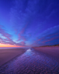 Poster - Seascape during sunrise. Long exposure. Bright clouds on the sky. Lines of sand on the seashore. Bright sky during sunset. A sandy beach at low tide. Wallpaper and background.