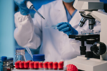 Wall Mural - medical or research scientist or doctor using looking at a test tube of clear solution in a lab or l