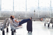 © Song_about_summer - woman relaxing and sleeping in the airport while waiting her flight in airport terminal transit lounge