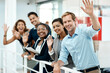 © peopleimages.com - Happy, business people and hand waving to new employee for hello, support and recruitment on office balcony. Smile, corporate group and team with welcome greeting for onboarding and collaboration