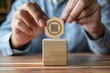 © Lucija - man placing certificate icon on wooden cube iso quality control guarantee in business and finance conceptual image