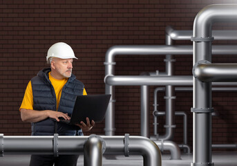Poster - man engineer in factory. pipes near guy with laptop. engineer inspects pipeline. worker with compute