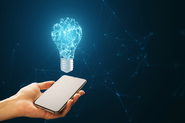Wall Mural - A person holding a smartphone with a digital lightbulb concept above it on a blue background, denoting a technology idea