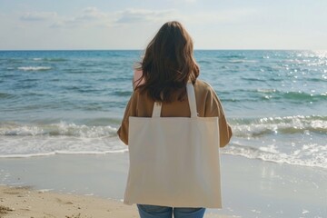 Wall Mural - woman with tote bag on beach traveling back view.