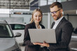 © anatoliycherkas - Portrait of two workers with laptop inside car showroom