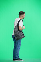 Wall Mural - A man, full-length, on a green background, with a backpack