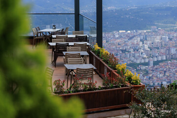 Beautiful views from above, tables in a cafe in the mountains and a panoramic view of the city, public places in Turkey, on a sunny summer day