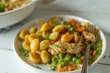 Wall Mural - Creamy chicken with peas and carrots. Served with pan fried gnocchi