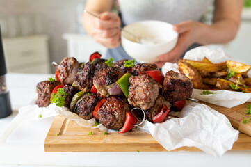Wall Mural - Delicious minced meat skewers with vegetables and potato wedges