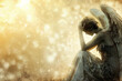 © RealPeopleStudio - A sad angel sitting in despair and anguish. Divine sparks in the background.