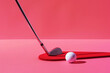 © ADDICTIVE STOCK - Minimalist golf club and ball on a red surface. Generative AI image