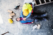 © Halfpoint - Colleague performing CPR on an injured worker lying on the ground after accident. Concept of occupational safety and health in workplace.