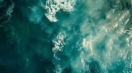 Aerial top down view of wavy ocean water with splashes and foam.