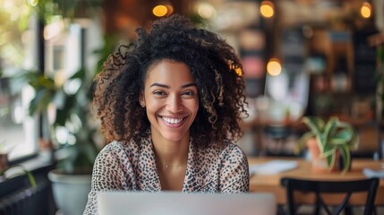 Young businesswoman sharing laughter and camaraderie with colleagues on a virtual team meeting via her laptop, fostering a positive and supportive work environment