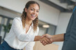 © polack - African American woman real estate agent shakes hands with a man in a business setting she is smiling and she is happy. Contract signing concept