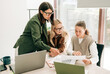 © Ilona - Business women are working at meeting and discussing the company's strategy. Colleagues use computers to work and analyze.
