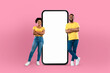 © Prostock-studio - Black couple positioned in front of a blank screen on a mobile phone, possibly engaged in a video call or taking a selfie. The screen shows no content