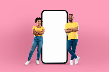 Wall Mural - Black couple positioned in front of a blank screen on a mobile phone, possibly engaged in a video call or taking a selfie. The screen shows no content