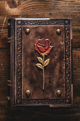 Wall Mural - Worn brown leather book with rose on the cover.