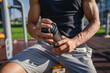 © Miljan Živković - One caucasian man young male athlete take a brake during outdoor training in the park outdoor gym hold supplement shaker in hand happy confident strong copy space