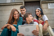 © Miljan Živković - group of students sit in front of school watch video on digital tablet
