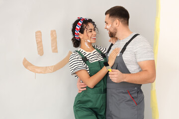 Wall Mural - Beautiful young happy couple with brush doing repair in new house