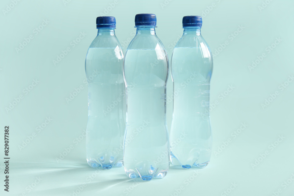 Plastic bottles of clean water on blue background