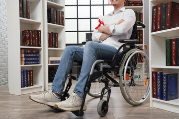 Wall Mural - Male graduate in wheelchair with diploma at library
