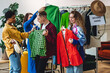 © ArtSys - Students, young attractive people shopping in secondhand store, trying vintage clothes, bargain hunting. Sustainable lifestyle of generation z, eco friendly conscious consumerism, consignment stores