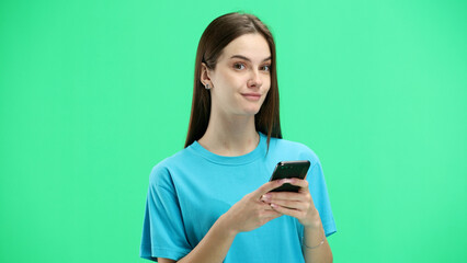 woman, close-up, on a green background, using a phone