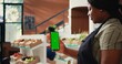 © DC Studio - African american vendor holding phone with greenscreen, presenting isolated chromakey layout on device at farmers market checkout. Woman using copyspace screen on smartphone. Tripod shot.