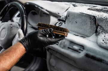 Wall Mural - A mechanic cleans the interior of a car with a brush and foam.