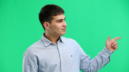 Wall Mural - A man, close-up, on a green background, points to the side