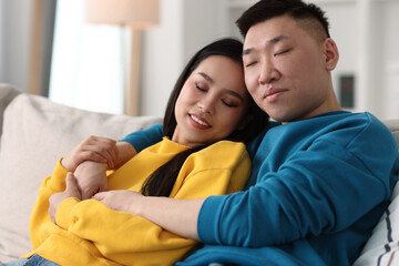 Poster - Happy young couple on sofa at home