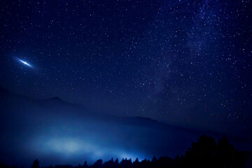 Wall Mural - Sky with twinkling stars over mountains at night