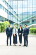 © metamorworks - オフィスビルの前に並ぶ多国籍ビジネスパーソンのグループ
