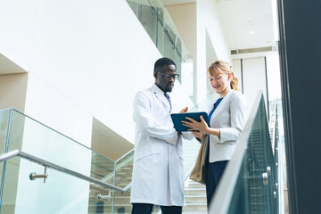 A researcher in a white coat and a female business person having a conversation in an office