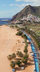 Wall Mural - Aerial view of the Las Teresitas beach and San Andres resort town in Tenerife, Canary Islands, Spain. Yellow sand beach, palm trees and coastal road. 