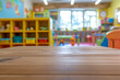 © grey - A wooden play table in the foreground with a blurred background of a children's playroom. The background includes colorful toys, bookshelves with children's books, soft play mats, and cheerful.