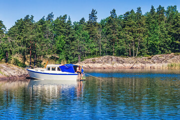 Poster - Man by his boat at the lakeshore at a sunny summer day