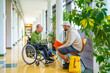 © unai - Man with disability talking with university colleague in the corridor