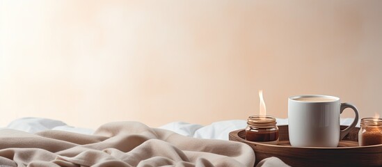 A cozy scene featuring a large white coffee mug on a bed with a fluffy pillow and a warm blanket providing a copy space image