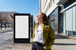 © Westend61 - Fashionable businesswoman with eyes closed standing near blank billboard on footpath in city