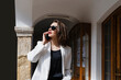 © Westend61 - Beautiful businesswoman wearing sunglasses talking on smart phone