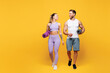 © ViDi Studio - Full body young fun strong fitness trainer sporty two man woman wear blue clothes spend time in home gym hold yoga mat look to each other isolated on plain yellow background Workout sport fit concept