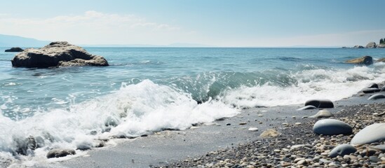 Wall Mural - Coastline with stone beach and white sea foam perfect for a copy space image