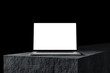 © guteksk7 - Laptop with a blank screen on a stone table, dark background. A modern scene perfect for placing your own content on the screen. Minimalist, professional look.