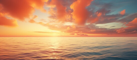 Poster - Orange clouds at sunset over the ocean creating a picturesque scene with a copy space image