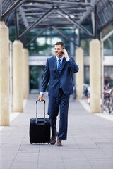 Canvas Print - Phone call, walking or businessman with luggage in communication, chat or deal conversation. Outdoor travel, talking and happy financial advisor networking for investment, negotiation or sales news